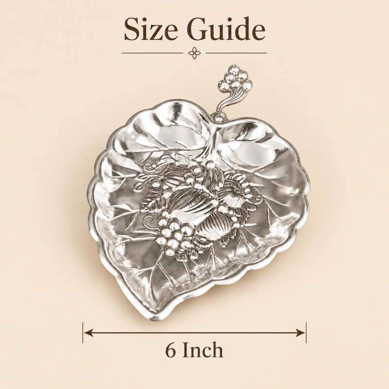 German silver gift item leaf-shaped serving dish with embossed floral and fruit design, shown with 6 inch size guide on beige background.