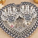 Close-up view of German Silver Haldi Kumkum Holder showing the fine detailing of the twin floral bowls, embossed heart-shaped tray, decorative scroll border, central traditional motif and highly polished reflective silver finish, highlighting the craftsmanship and ornamental design for pooja and gifting