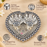 German Silver Haldi Kumkum Holder features image highlighting the elegant silver finish, twin bowls for haldi and kumkum, ornamental heart-shaped tray, detailed traditional border work and decorative embossed pattern, designed for pooja ceremonies, festive use, religious rituals, weddings and gifting occasions