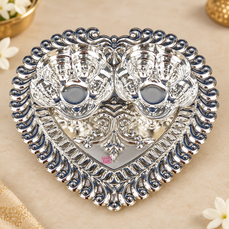 German Silver Haldi Kumkum Holder featuring a decorative heart-shaped tray with two attached flower-shaped bowls, intricate embossed border detailing, polished silver finish and traditional ornamental pattern, suitable for haldi kumkum ceremonies, pooja rituals, festive occasions, wedding functions, housewarming ceremonies, return gifting and traditional Indian home decor