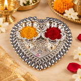 German Silver Haldi Kumkum Holder arranged for traditional pooja use with yellow haldi powder and red kumkum placed in the two attached decorative bowls, surrounded by flowers and festive accessories, suitable for religious ceremonies, Diwali, weddings, housewarming events, haldi kumkum functions and daily pooja