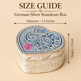 Size guide image of a German Silver Heart-Shaped Kumkum Box showing approximately 1.5 inch diameter and 1 inch overall height with clear measurement arrows, while displaying the compact heart-shaped body, engraved floral and paisley lid, decorative border detailing, polished silver-tone finish and traditional craftsmanship, helping customers understand the small dimensions and proportions before purchasing for pooja use, return gifting, festive occasions or decorative storage.