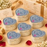 Multiple matching German Silver Heart-Shaped Kumkum Boxes arranged neatly in a premium festive gifting setup with elegant gift boxes, ribbon details and decorative accents, showcasing the engraved heart-shaped lids, floral and paisley patterns, compact traditional form and polished silver finish, suitable for wedding return gifts, housewarming favors, pooja giveaways, festive gifting, religious functions, family celebrations and larger bulk order requirements.