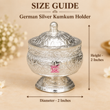 Size guide image of a German Silver Kumkum Holder showing approximately 2 inch diameter and 2 inch overall height with clear measurement arrows, while displaying the round floral engraved body, domed lid with top knob, polished silver finish and pedestal base on a premium beige background, helping customers understand the compact size and proportions before purchase for storing kumkum, roli, sindoor or other pooja essentials and for use as a small traditional gift item.