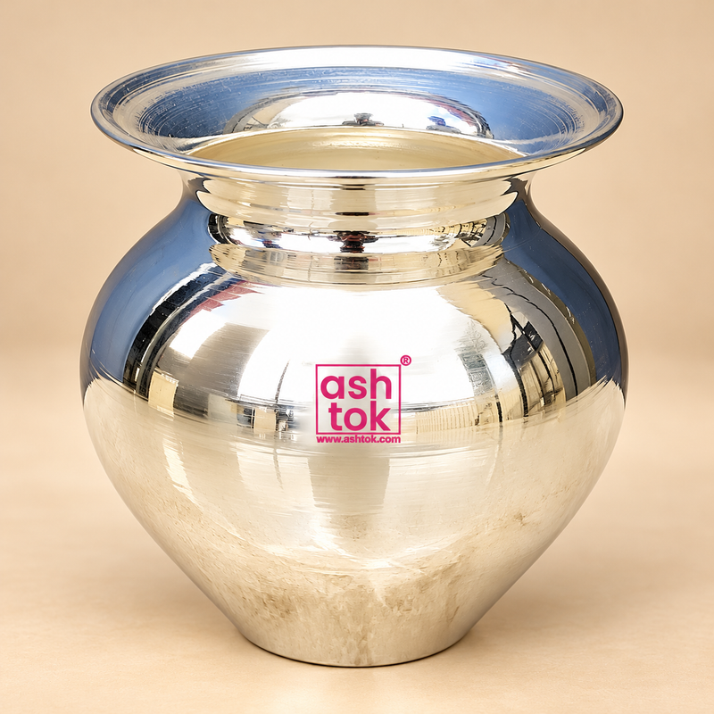Traditional German Silver Lota featuring an elegant rounded water pot design with a broad flared mouth, beautifully polished silver finish, narrow decorative neck and smooth bulbous body tapering towards a stable base. The vessel has a highly reflective mirror-like metallic surface with subtle handcrafted texture and fine circular detailing around its wide upper rim. Photographed against a soft premium beige studio background with gentle lighting and natural shadow.