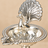 Close-up view of German Silver Peacock Diya showing detailed peacock feathers, polished silver surface, decorative rim, embossed diya bowl and fine craftsmanship of the traditional design