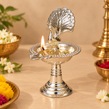 Lit German Silver Peacock Diya displayed with flowers and traditional festive decor, ideal for daily pooja, Diwali celebrations, home temple decoration, religious ceremonies and auspicious occasions
