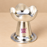 Front angle view of German Silver Puja Diya showing the lotus petal style upper bowl, tapered pedestal body, polished metallic finish and broad round base, giving a clear view of the compact traditional design for daily pooja, religious rituals, festive use and gifting