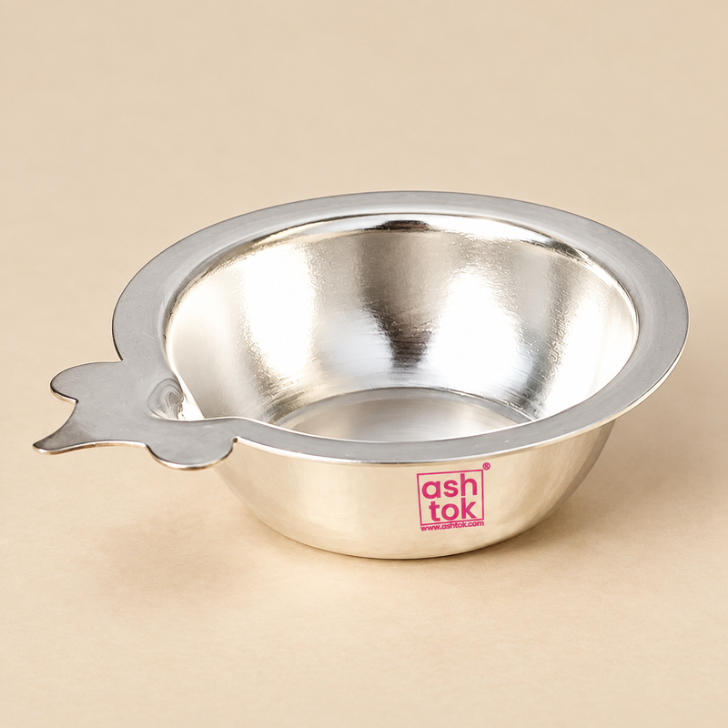 Traditional German Silver Puja Diya with a polished neutral silver finish, shallow round bowl, wide smooth flared rim and distinctive flat side wick-holder extension, photographed as a clean main product image on a premium beige studio background with soft lighting and subtle shadow, showing the complete diya shape clearly for daily puja, home mandir use, festive rituals, Diwali worship, religious ceremonies, pooja thali arrangements, traditional gifting and devotional decor.
