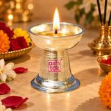 Lit German Silver Round Diya displayed in a traditional festive pooja setting with a glowing flame, flowers and decorative ceremonial accessories, showcasing its use for daily prayers, home mandir lighting, Diwali, Navratri, weddings, housewarming functions and other auspicious religious occasions