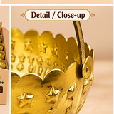 Detailed close-up of a gold coated flower gift basket showing the scalloped rim, embossed star and floral motifs, polished golden surface, curved handle attachment and decorative metal craftsmanship, allowing customers to clearly view the finish and design details before purchase.