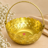 Detailed close-up of gold coated flower basket highlighting the embossed star and floral motifs, scalloped rim, smooth golden interior, textured curved handle and side attachment points, showing the decorative craftsmanship and premium finish of the basket.