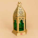Decorative gold metal lantern with green glass panels and intricate cutout design, ideal for home décor, Ramadan, Diwali, festive displays, and candle lighting.