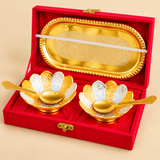 Top-view product photograph of a five-piece Gold and Silver Plated Dry Fruit Serving Set consisting of one oval decorative tray, two matching flower-shaped bowls, and two engraved golden serving spoons. The bowls feature alternating gold and silver petal-shaped sections with detailed floral engravings, while the 8-inch-long tray displays an intricate ornamental centre pattern and raised beaded border. The coordinated design is suitable for decorative table settings, festive dry fruit serving, wedding return