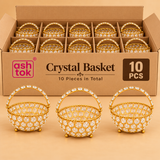 Set of 10 decorative golden crystal baskets featuring a round open basket design embellished with clear faceted crystal stones, braided golden rim, elegant curved carrying handle and small metallic ball feet. The baskets are arranged in individual compartments inside a brown cardboard packaging box, with three additional sample baskets displayed in front to highlight the detailed crystal work. Suitable for wedding return gifts, housewarming gifts, festive celebrations and decorative gifting arrangements.