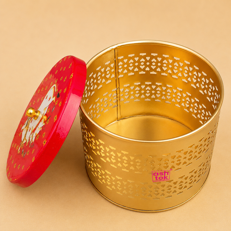 Open decorative golden metal storage box with laser-cut pattern and red cow design lid, ideal for return gifts, dry fruit storage, festive gifting, and home decor by Ashtok.