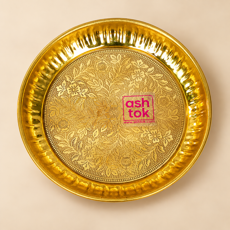 Handcrafted brass puja plate with intricate floral engraving, polished golden finish and decorative fluted rim, professionally presented on a premium beige studio background for pooja, mandir use and traditional ceremonies.
