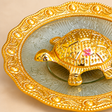 Close-up view of Handcrafted Brass Tortoise Plate highlighting the intricate tortoise shell detailing, polished brass finish, decorative embossed plate surface and scalloped ornamental border. This detailed image emphasizes the craftsmanship, texture and traditional design of the product, making it suitable for puja decor, gifting and elegant housewarming presentation.