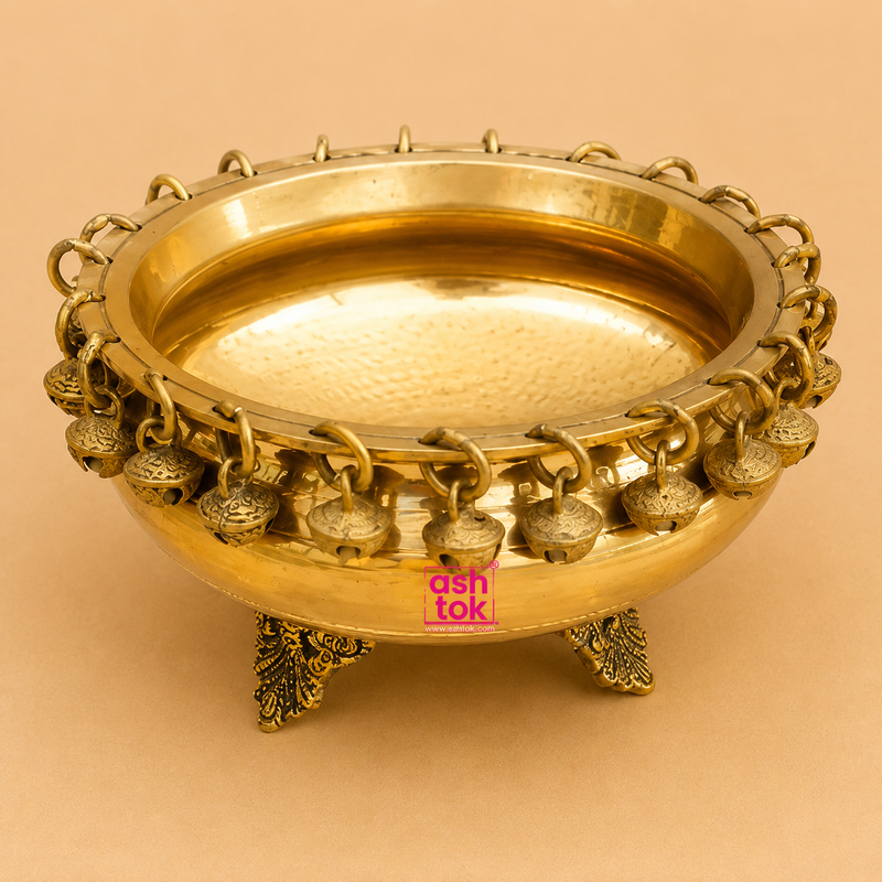 Handcrafted brass urli with decorative hanging bells and ornate legs, ideal for floating flowers, candles, festive décor, pooja, Diwali, weddings, housewarming, and traditional home decoration.