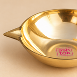 Close-up image of a Matt Finish Brass Pankti Diya showing the smooth brass surface, shallow bowl contour, clean rim and pointed spout detail. The close-up highlights the craftsmanship and finish of the traditional brass diya.