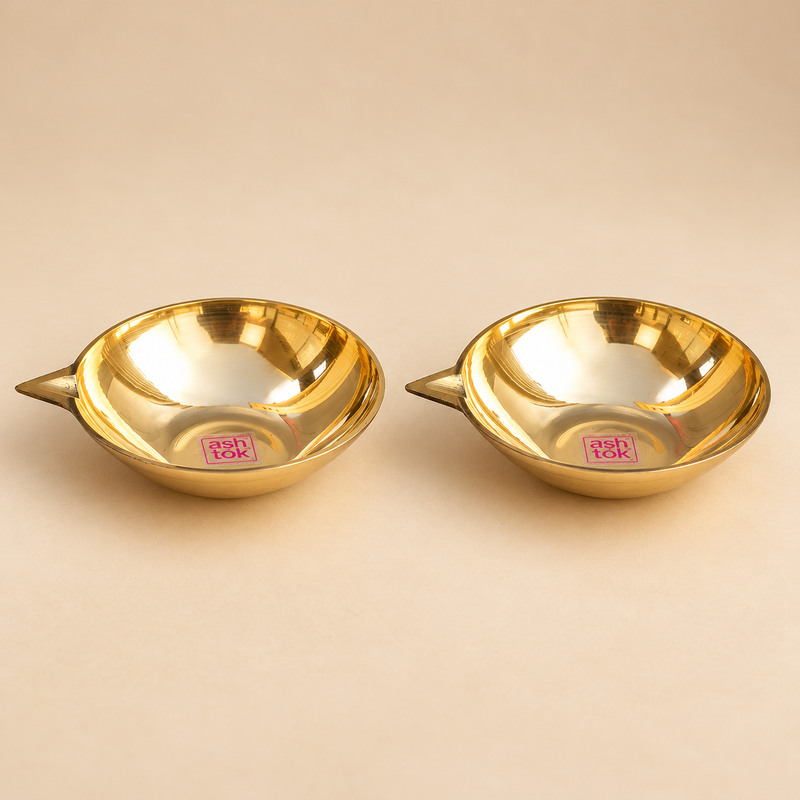 Set of 2 Matt Finish Brass Pankti Diyas with wide shallow oil bowls, pointed traditional spouts and smooth polished brass finish, displayed on a clean beige studio background. Each brass diya measures 5 inches in diameter and 1.5 inches in height, suitable for pooja, festive decoration, Diwali lighting and traditional home decor.