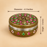 Dimension diagram showing a single round stainless steel Meenakari Puri box placed against a neutral background. Black measurement lines and text indicate a top diameter of 4.5 inches across the lid and a vertical height of 2 inches along the side. The box is adorned with antique brass-style metalwork featuring a peacock motif with pink, green, and white enamel details on the top lid and an intricate floral Meenakari pattern wrapping around the outer side wall.