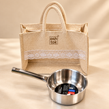 Prestige Triply stainless steel saucepan 14 cm 1 litre with long handle and reusable gift bag on a premium beige studio background