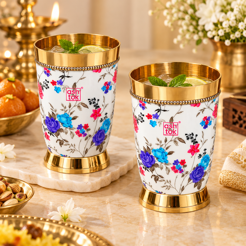 Floral printed brass glasses styled with chilled beverages, ice, mint and lemon in an elegant festive setting, showing their use for serving water, juices, mocktails and drinks during celebrations and special occasions.