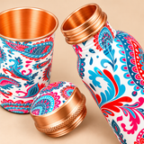 Close-up of printed copper bottle with matching glass showing detailed print, copper finish and cap