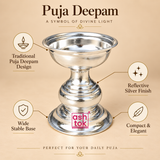 Feature presentation of a traditional Puja Deepam with polished silver finish, wide stable circular base, compact elegant pedestal shape, shallow reflective oil bowl and decorative turned body detailing, shown on a premium beige background with callouts highlighting the traditional deepam design, reflective finish, stable base and compact form for daily pooja, home mandir, festive rituals and devotional use.
