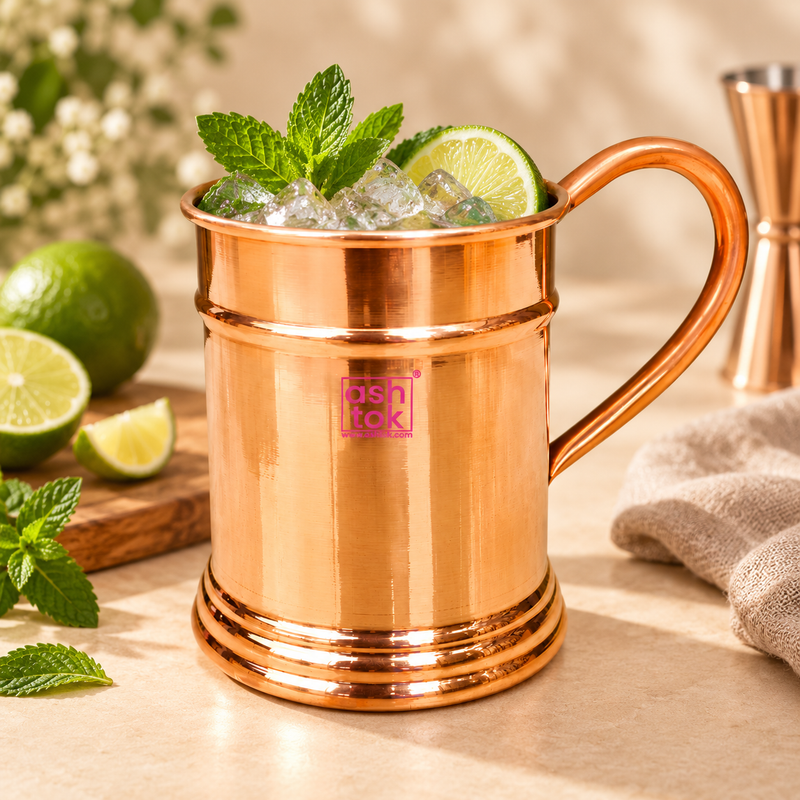 Pure copper Moscow Mule mug styled with ice, fresh mint and lime in a premium beverage setting, showing its use for cocktails, mocktails and chilled drinks at parties, home bars, restaurants and special occasions.