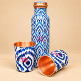 Blue printed pure copper water bottle with two matching glasses shown from an alternate angle