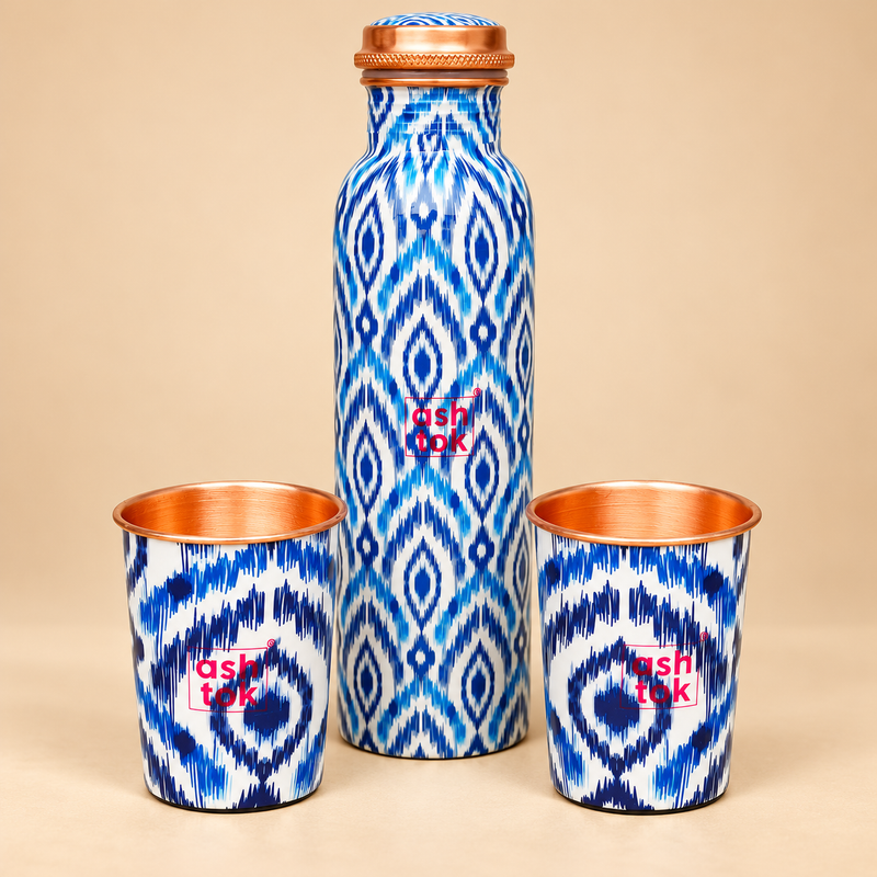 Pure copper water bottle with 2 matching glasses in blue printed design on beige background