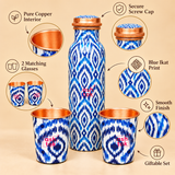Features image of pure copper water bottle with 2 glasses highlighting copper interior, screw cap, blue print design, and smooth finish