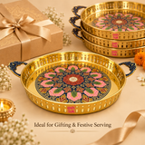 ASHTOK decorative brass round serving tray presented for festive gifting and bulk orders, featuring a premium golden brass finish, colorful floral center design, ornate blue handles and elegant presentation suitable for weddings, festivals, corporate gifting and special occasions.