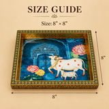 Wood Cow Tray size guide image showing the handcrafted decorative tray in approximately 8 inch by 8 inch size, featuring ornate floral border detailing, a rich gold-toned frame, and a traditional cow and calf artwork set against a deep blue decorative background.