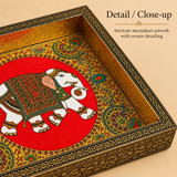 Detail close-up image of Wood Peacock Tray Meenakari Design focusing on the intricate meenakari elephant artwork, rich red center panel, ornate hand-finished border, engraved floral frame, and decorative craftsmanship of the tray.