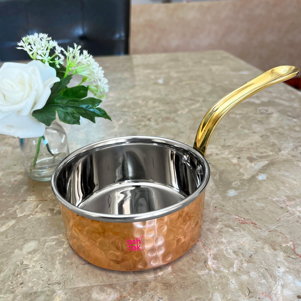 Hammered copper saucepan with brass handle, designed for cooking, serving, and enhancing traditional kitchen aesthetics.