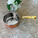 Heavy gauge copper saucepan with brass handle for efficient heating, cooking, and food preparation in home kitchens.
